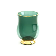 A translucent teal green glass cup with a flared gold-colored base and a thin gold rim, shown on a plain white background.
